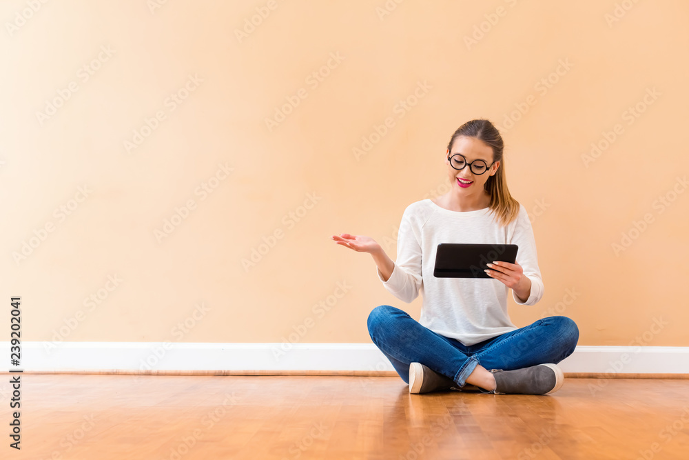 Young woman with a tablet computer against a big interior wall Young woman with a tablet computer against a big interior wall