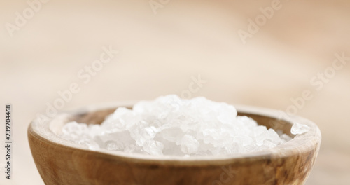 Closeup   of coarse sea salt in wooden bowl on table