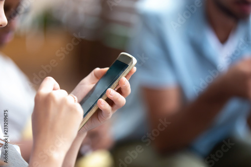 Young woman holding phone in hands, reading message, news, browsing internet, online mobile apps, using device at meeting, looking at screen, technology addiction, hands view close up