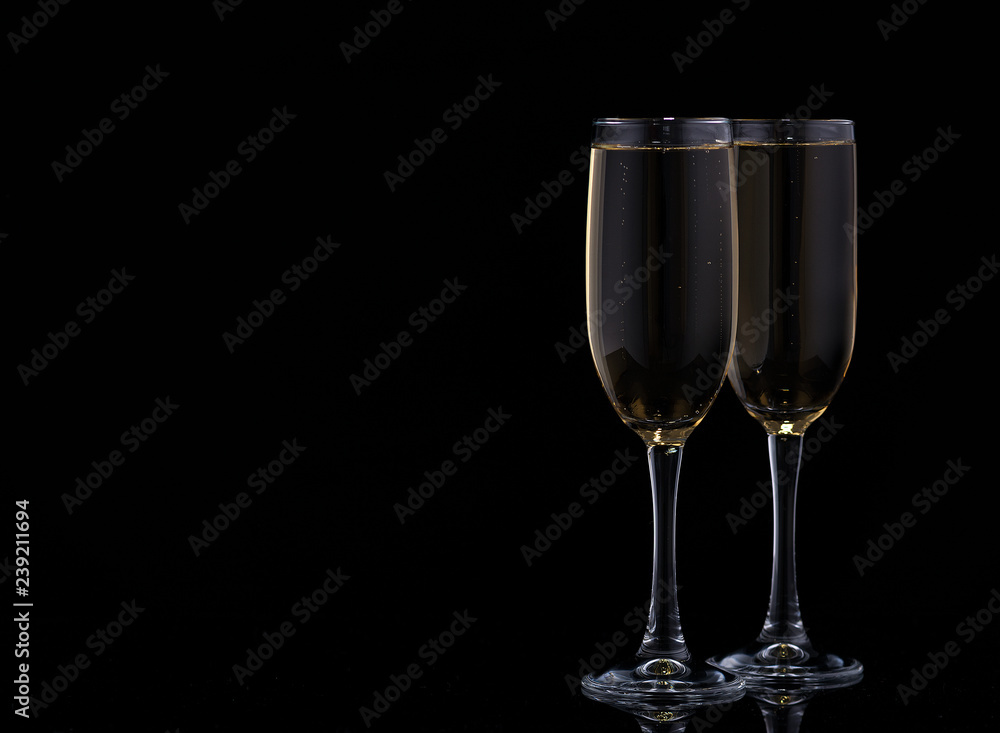 Two glasses with champagne on a black background.