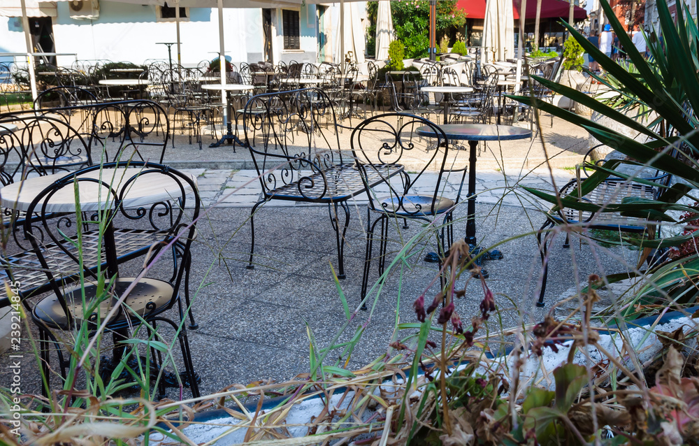 Obraz Czarne metalowe krzesła i stoły ulicznej kawiarni stojącej na dworze