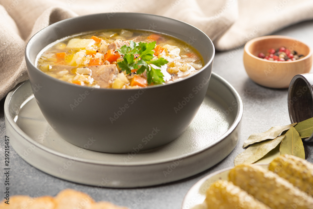 Rassolnik - Traditional Russian soup with pickled cucmbers, pearl barley, meat, pickles, carrots and potatoes on light background