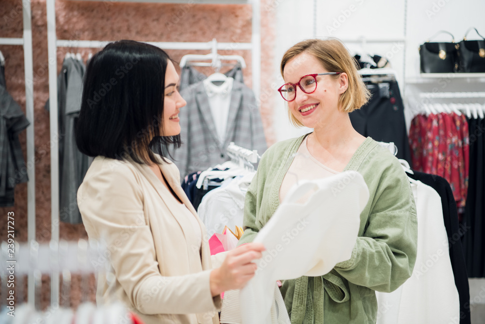 Fashion consultant showing clothes to the client Fashion consultant showing clothes to the client