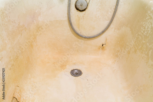 Rusty old bath with peeling enamel. Repair is required.