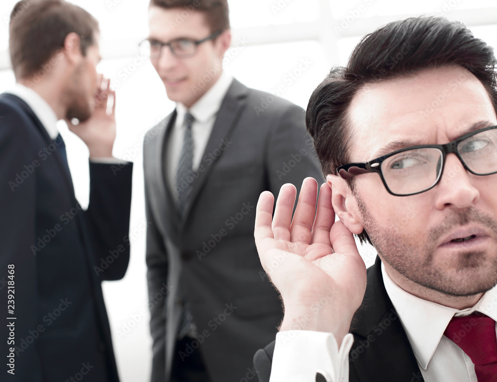 close up.businessman eavesdropping on conversation between colleagues close up.businessman eavesdropping on conversation between colleagues