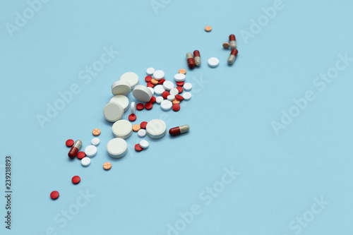 Assorted multicolored pills on blue background