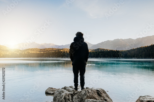 Mensch von hinten schaut auf wunderschönen See bei Sonnenaufgang photo