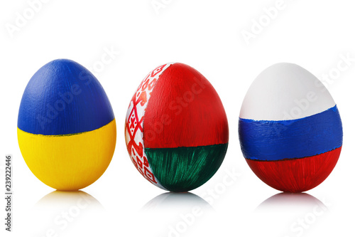 Three Easter eggs painted in colors of the flags of Ukraine, Belarus and Russia isolated on a white background