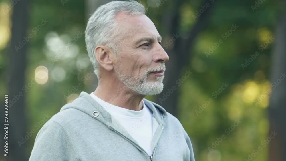 Smiling man drinking bottled beverage, keeping water balance after workout Smiling man drinking bottled beverage, keeping water balance after workout