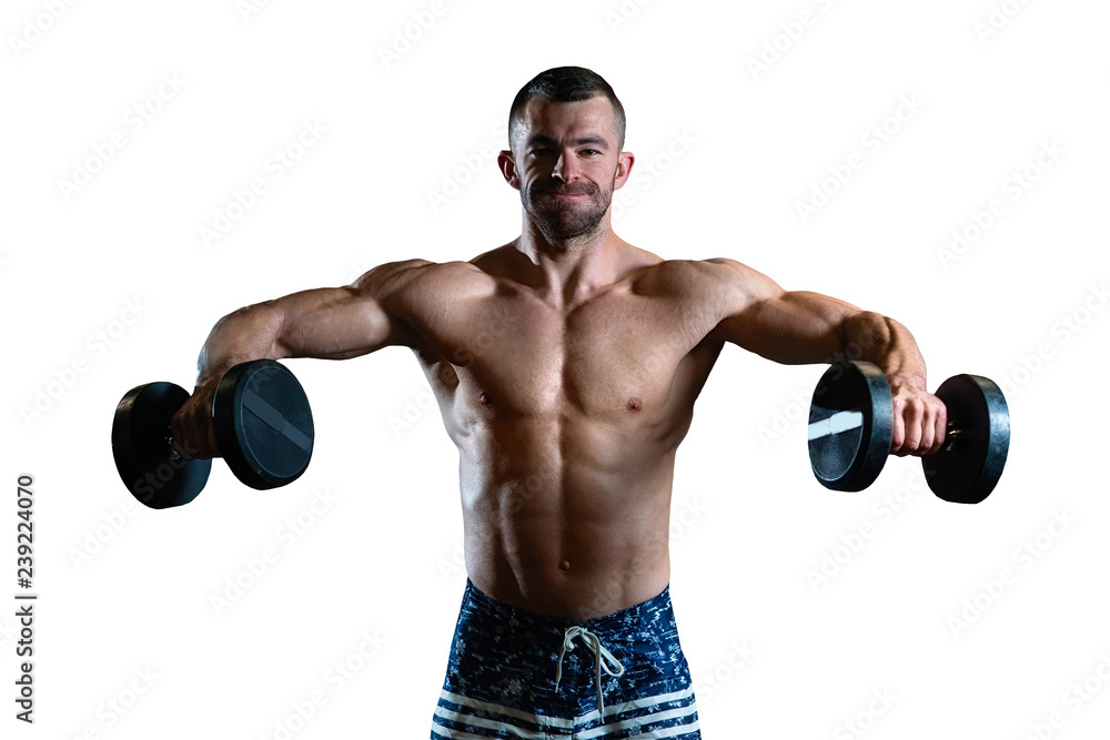 young muscular man trains his shoulders with dumbbells on white background