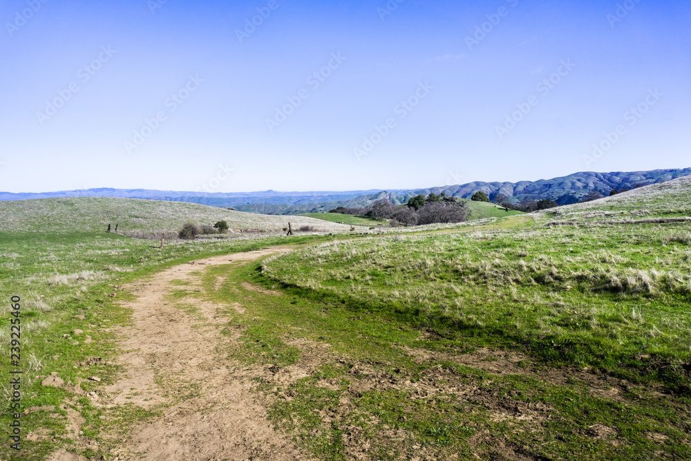 Hiking trail through the green hills and valleys of Sunol Regional Wilderness, east San Francisco bay area, California
