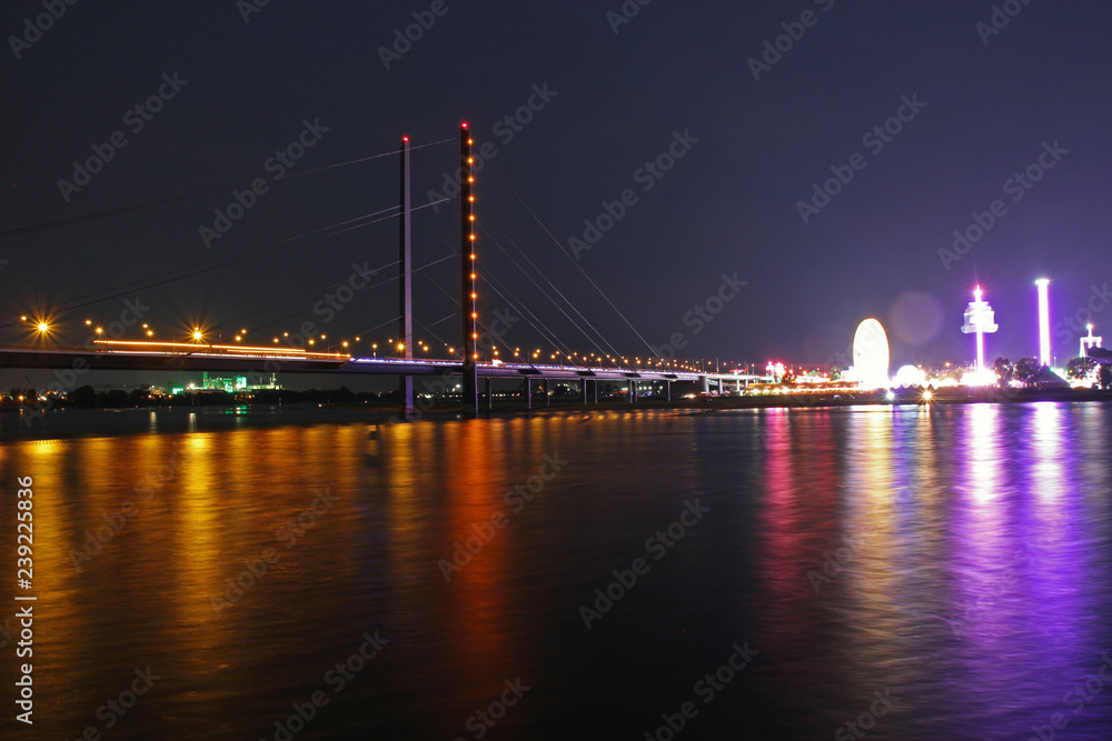 long time exposure of the rhine bridge with colorful lights of the funfair