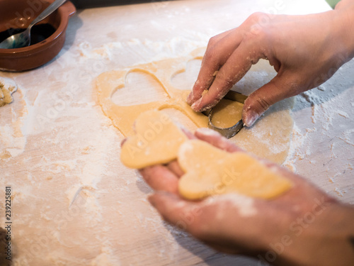 Woman cutting out heart shaped christmas cookies