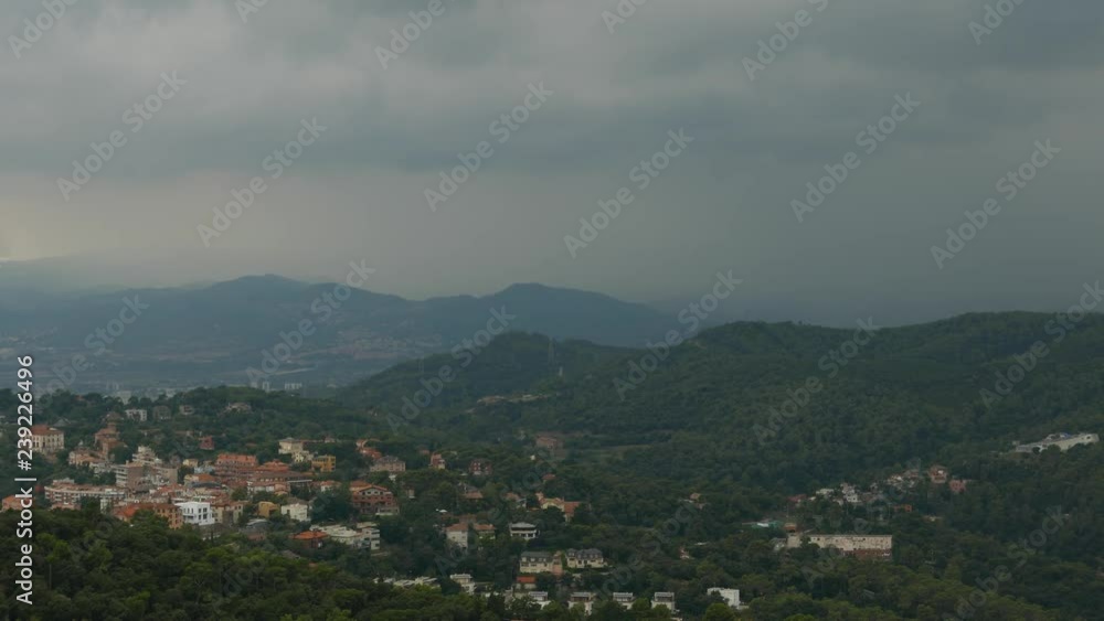 Dark rainy clouds over cozy valley village, Barcelona Dark rainy clouds over cozy valley village, Barcelona