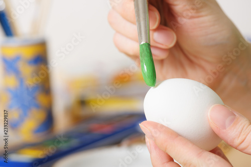 Close up of female hands coloring easter eggs