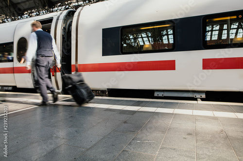 Person mit Koffer am Bahnhof ist in Eile photo