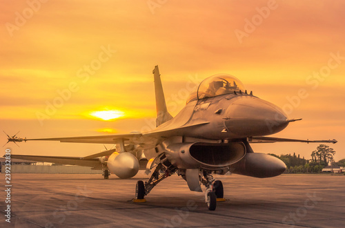 Silhouette fighter jet military aircrafts parked on runway in twilight sunset time 