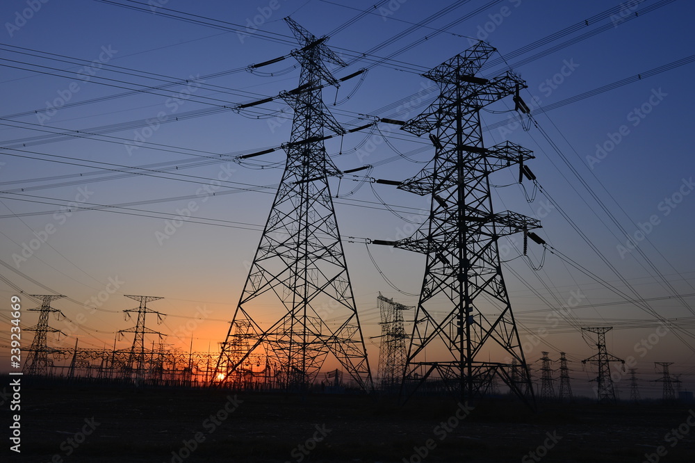 Fototapeta premium The silhouette of the evening electricity transmission pylon