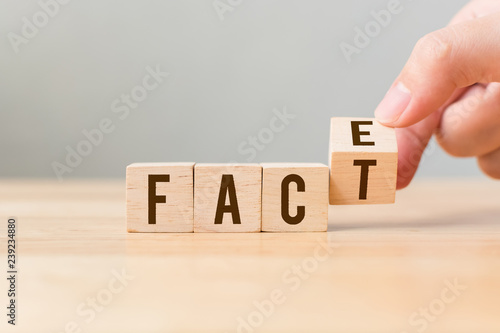 Foto Face to Facts concept. Hand flip over wooden cube block