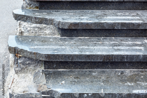 Dark marble steps with broken corners dangerous to climb up, close-up of a dangerous staircase.