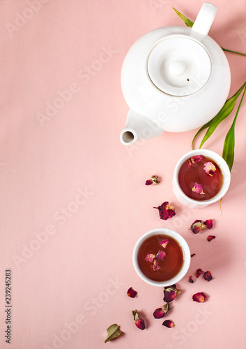 Herbal tea with roses on pink background
