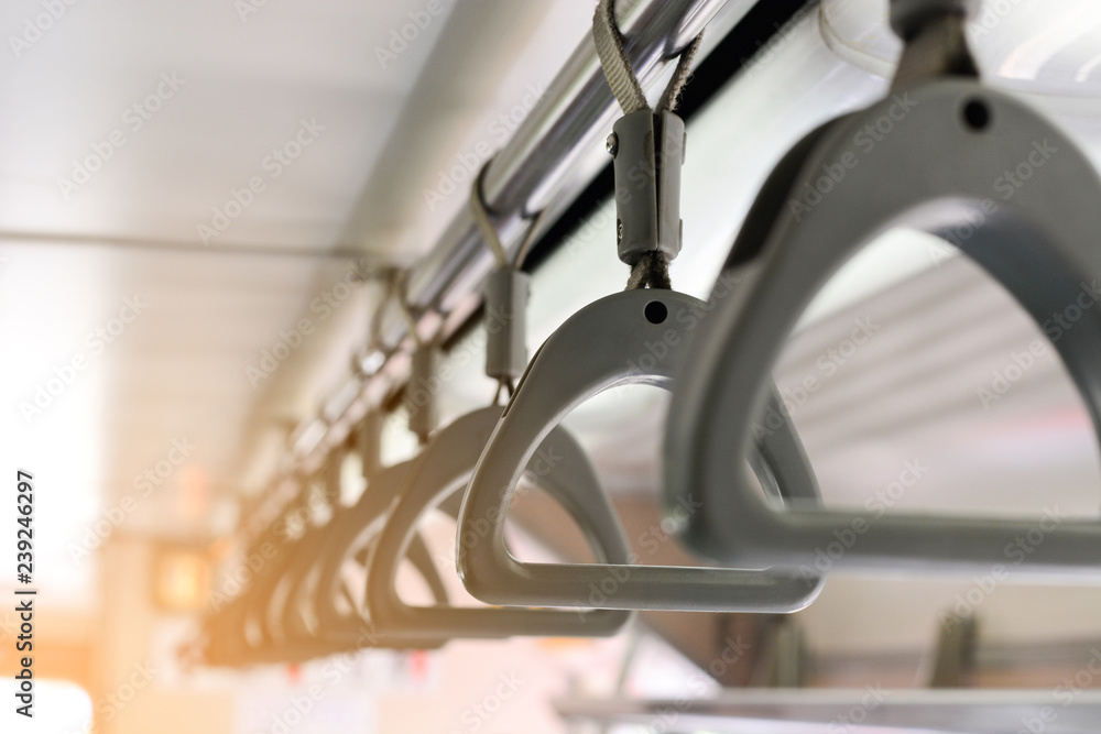 gray plastic handles on ceiling rails for standing passenger, handle in underground railway system or metro or Mass Rapid Transit (MRT), use for people holding on the train or the bus blur background gray plastic handles on ceiling rails for standing passenger, handle in underground railway system or metro or Mass Rapid Transit (MRT), use for people holding on the train or the bus blur background