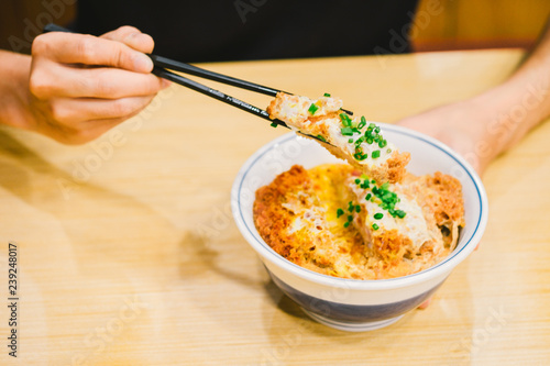 man eat Tonkatsu or katsudon. Japanese deep-fried pork cutlet with egg and rice