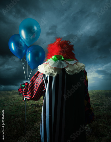 Scary clown on a field at night Fototapeta