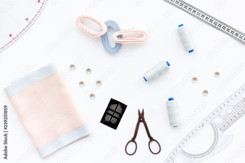 Woman hobby. Set for tailor shop with thread, scissors, fabric on white background top view Woman hobby. Set for tailor shop with thread, scissors, fabric on white background top view