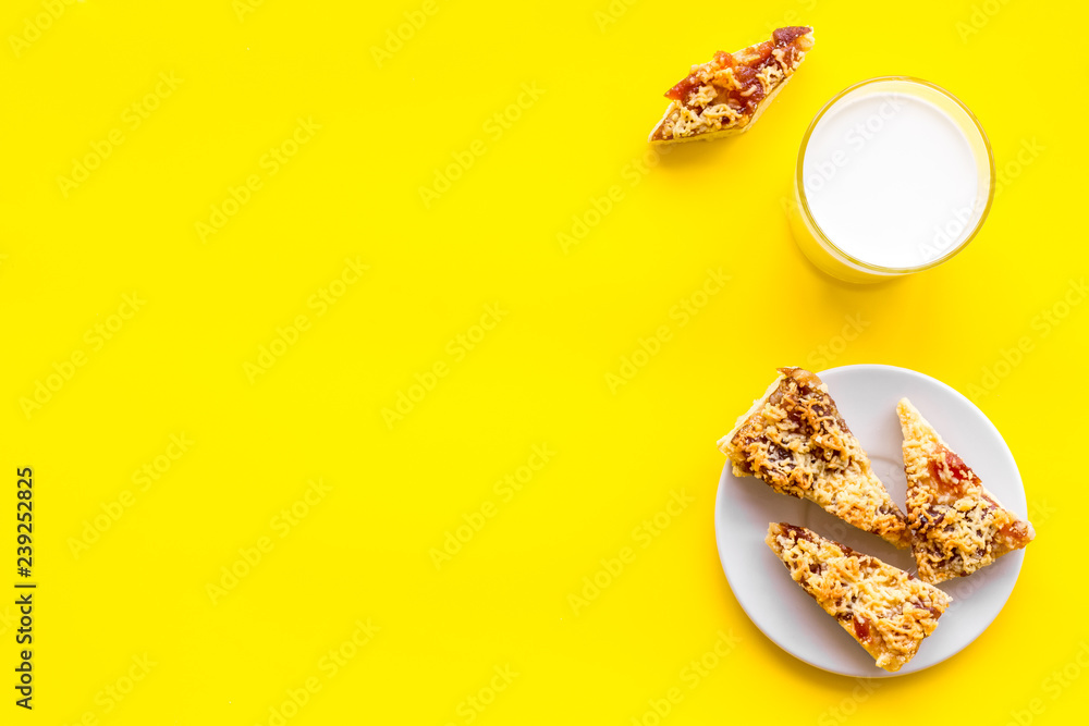 Drink milk with cookies concept. Cup of milk and fresh homemade cookies on yellow background top view copy space