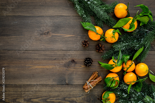 branch of mandarins, fir tree and cinnamon for New Year and Christmas celebration on wooden background top view mockup