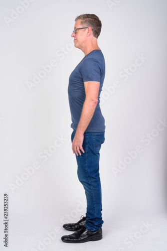 Full body shot profile view of mature man against white background
