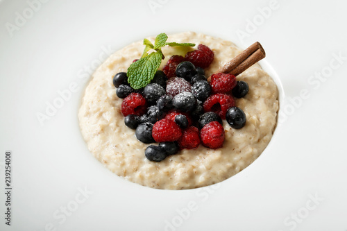 Close up of oatmeal with berries on white plate