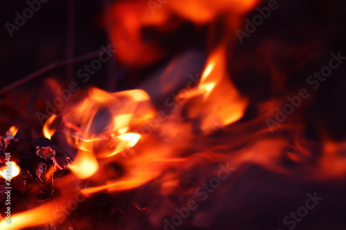 Abstract flame background image. Orange and red fire on a dark background. Cropped shot, close up, blurred