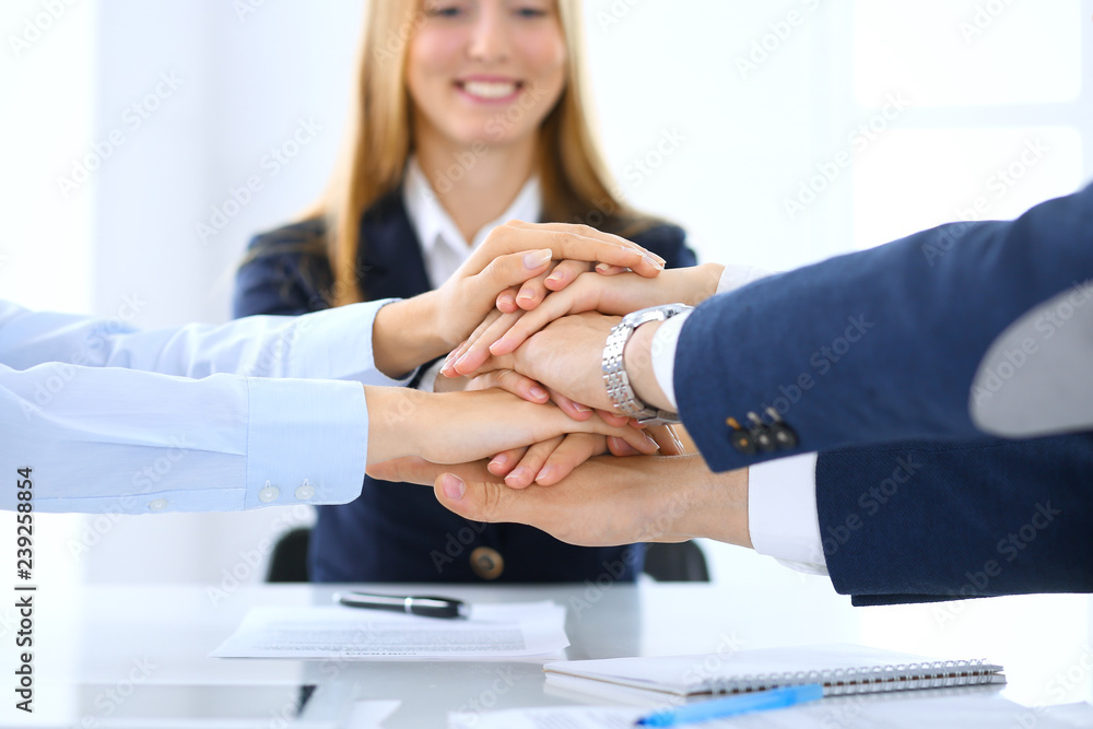 Business team showing unity with their hands together. Group of people joining hands and representing concept of friendship, teamwork and partnership Business team showing unity with their hands together. Group of people joining hands and representing concept of friendship, teamwork and partnership