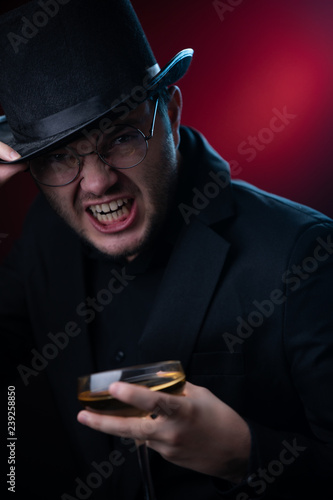 Photo of man in black hat with glass in hands