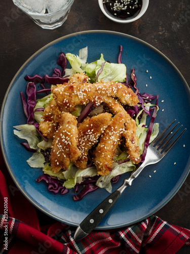 Salad with warm glazing chicken, sprinkled with sesame seeds. Chinese cuisine. Asian culture