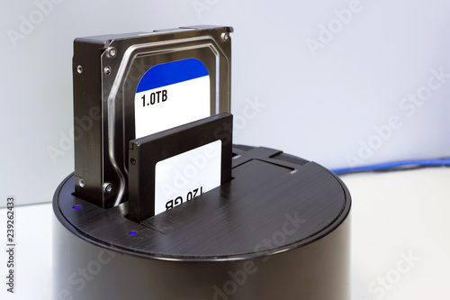 Hdd and ssd hard drives in the black rounded docking station. Illustration of repair and diagnostics hard drives or backup and restore information, formatting, copy, checking for bad sectors.