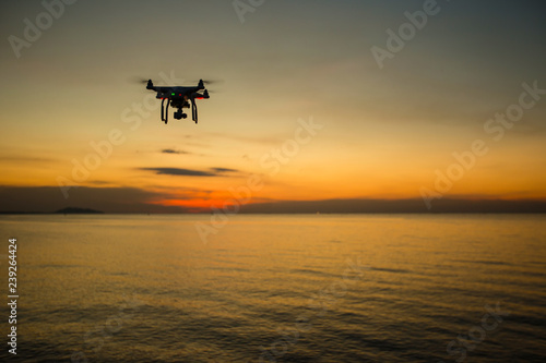 UAV drone copter flying with digital camera.Drone with high resolution digital camera. Flying camera take a photo and video.The drone with professional camera takes pictures of the sky and sea.