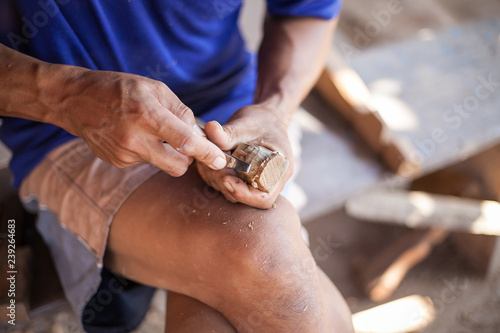 man is carving the wood