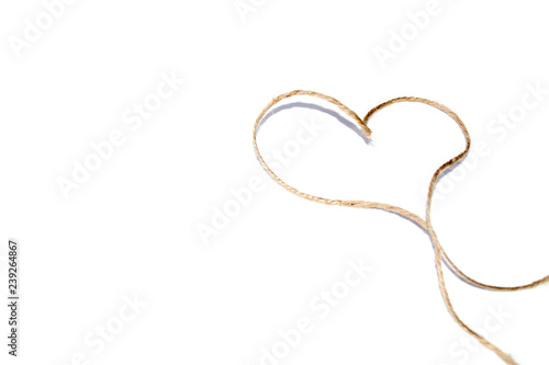 Isolated jute rope with shape heart on white background. Concept of love, celebration, care, health, life.
