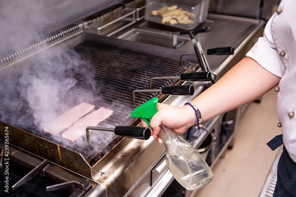 Obraz premium Grilled bacon by chef in kitchen restaurant. Delicious fast cuisine