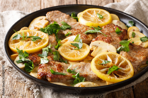 Stampa su tela Italian main course veal scaloppini cooked with mushrooms and lemons in a spicy sauce, close-up