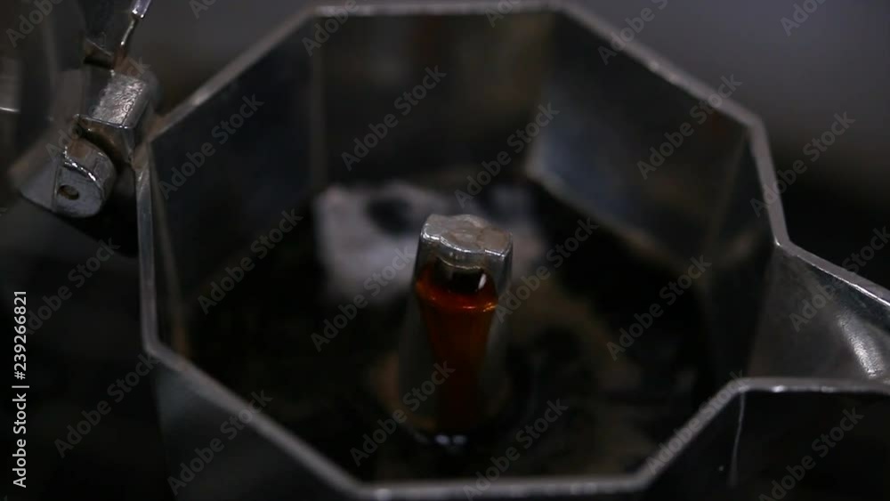 Close up of Coffee building up by pressure in Moka coffee pot on stove. Italian old style coffee brewing Close up of Coffee building up by pressure in Moka coffee pot on stove. Italian old style coffee brewing