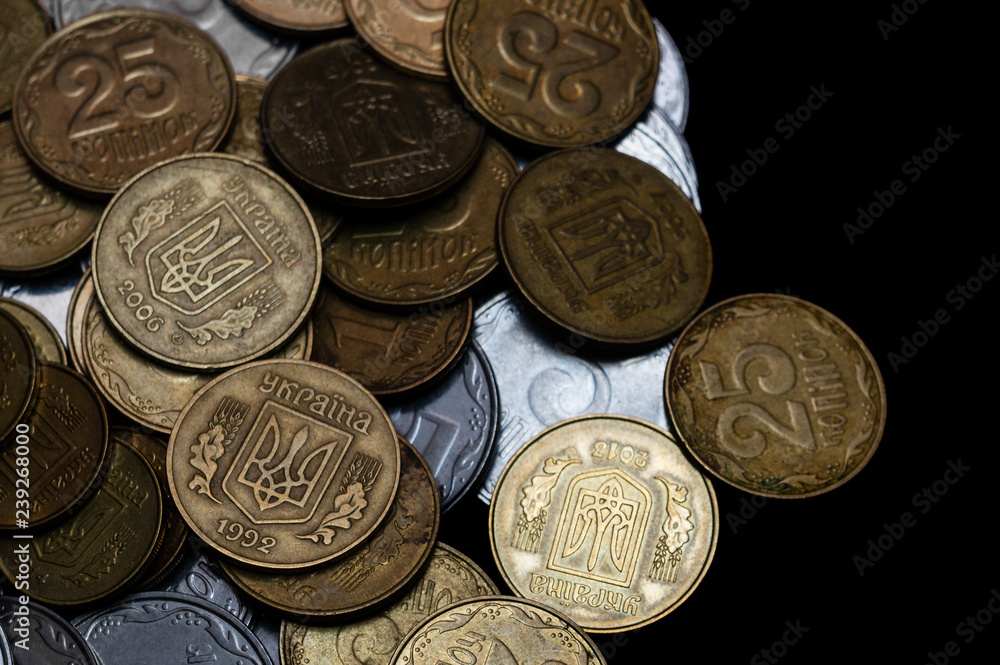Ukrainian coins isolated on black background. Close-up view. Coins are located at the left side of frame. A conceptual image. Ukrainian coins isolated on black background. Close-up view. Coins are located at the left side of frame. A conceptual image.