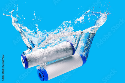 Foto New carbon filter cartridge for house water filtration system isolated on blue background
