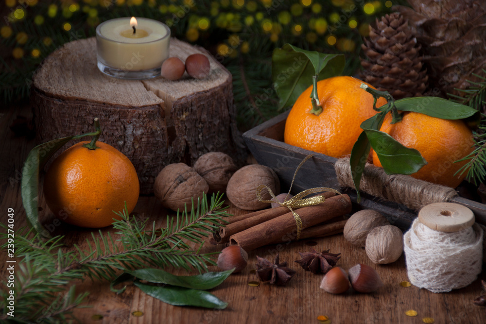 Tangerines with leaves in a box with cinnamon sticks Tangerines with leaves in a box with cinnamon sticks