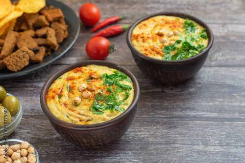 Classic hummus in bowls on wooden table