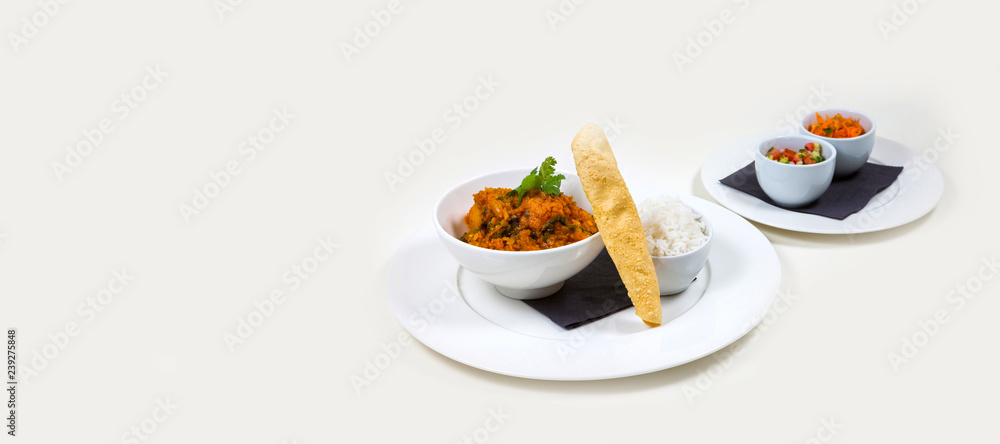 Indian Curry in a white bowl with rice on a white plate on a white background isolated Indian Curry in a white bowl with rice on a white plate on a white background isolated
