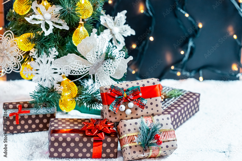 Christmas gifts in the snow under the tree. The concept of home holiday, surprises and present